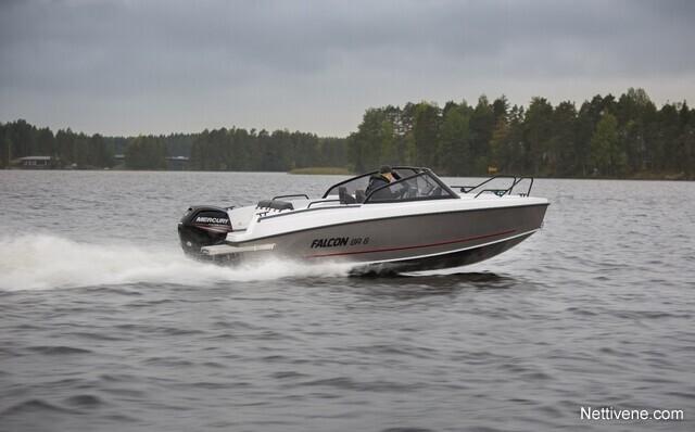 A Falcon 600 G boat speeds across a lake, creating a spray of water, surrounded by green trees and cloudy skies.